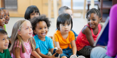 Children in their classroom listening to their teacher