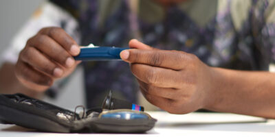 Young person with diabetes using glucose tester.